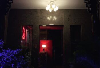 Entrance to 69 Sauna, a gay sauna in Ho Chi Minh City, Vietnam. Dark stone facade with red accents and a glowing chandelier. Gay travel advice.