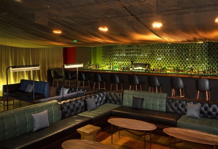 Mesh interior of a gay bar. Stylish seating, bar stools, and a well-stocked bar create an inviting atmosphere for gay men travel.