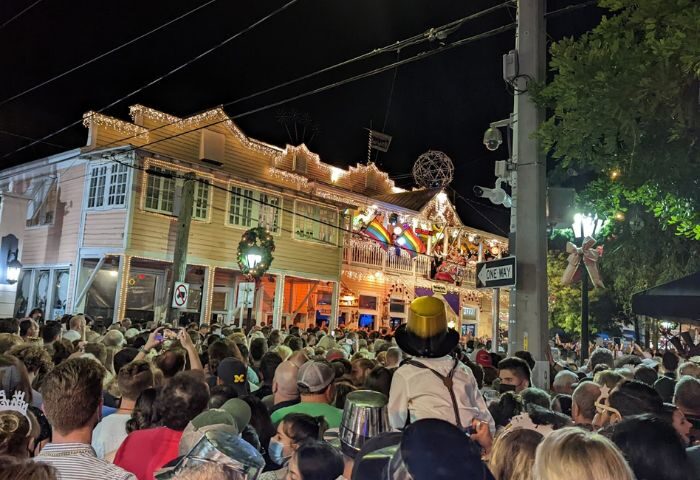 Gay party at 801 Bourbon Bar in Key West. Crowd gathers for drinks, festive lights, and rainbow flags. Gay travel destination.