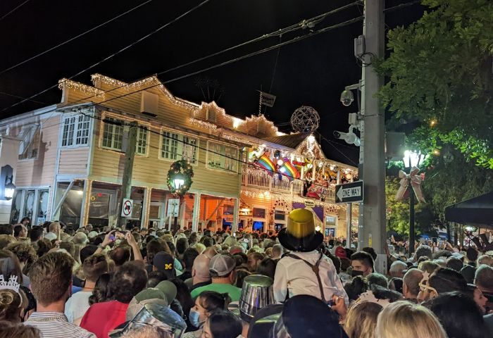 Gay party at 801 Bourbon Bar in Key West. Crowd gathers for drinks, festive lights, and rainbow flags. Gay travel destination.