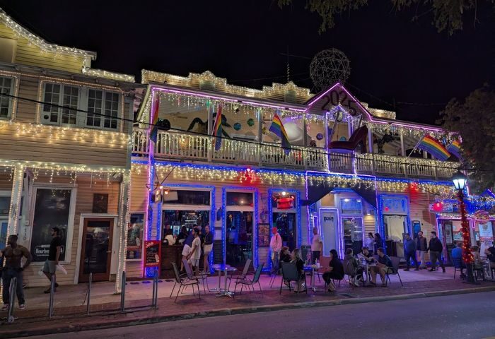Bourbon St. Pub, a gay bar in Key West, Florida. Rainbow flags, lights, and people enjoying drinks. Gay travel destination.