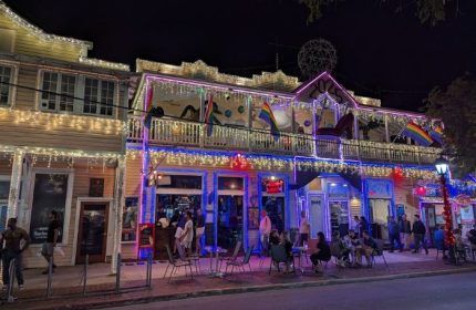 Bourbon St. Pub, a gay bar in Key West, Florida. Rainbow flags, lights, and people enjoying drinks. Gay travel destination.