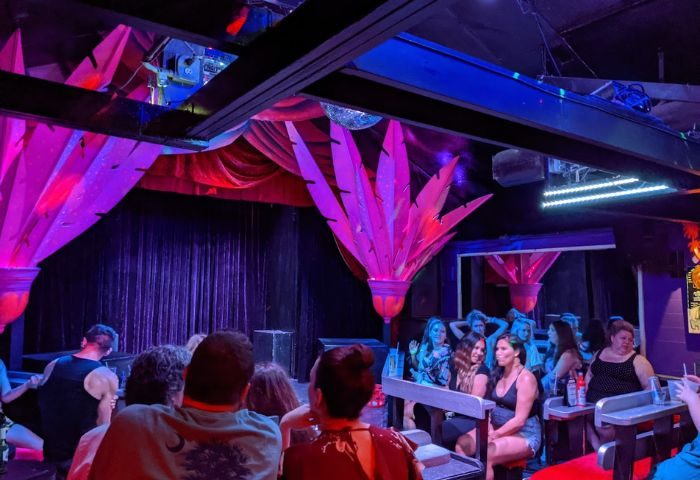 Gay party at 801 Bourbon Bar in Key West. People enjoy drinks at a show in a vibrant, colorful gay bar. Gay travel advice.