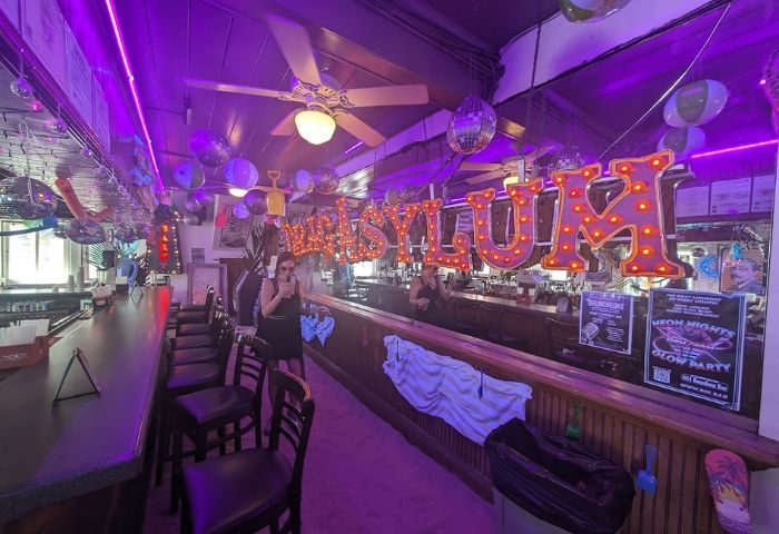 Inside 801 Bourbon Bar, a gay party spot in Key West. Disco balls, balloons, & neon lights create a fun atmosphere for drinks.