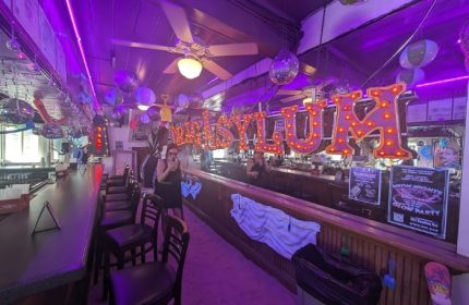 Inside 801 Bourbon Bar, a gay party spot in Key West. Disco balls, balloons, & neon lights create a fun atmosphere for drinks.