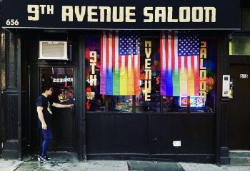 9th Avenue Saloon, a gay bar in New York. Rainbow flags hang in the window. A man enters the bar. Gay travel destination.