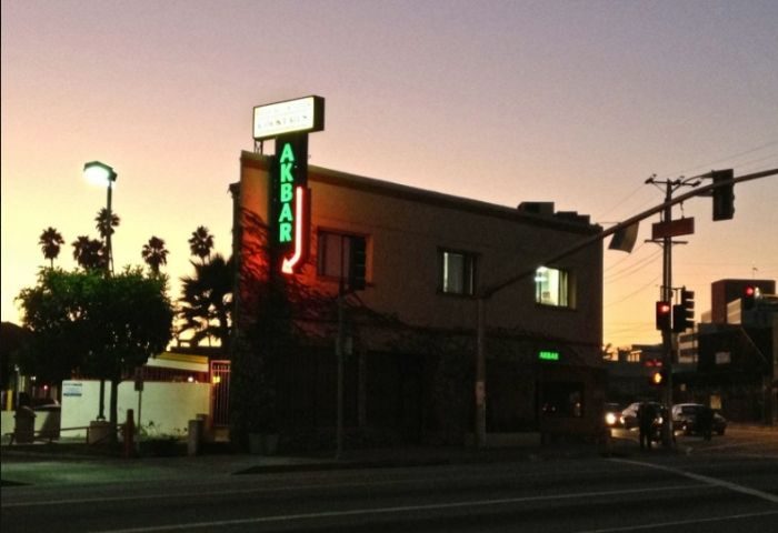 Akbar gay bar location at sunset. Green neon sign. A popular gay travel destination. Los Angeles nightlife. Akbar's exterior.