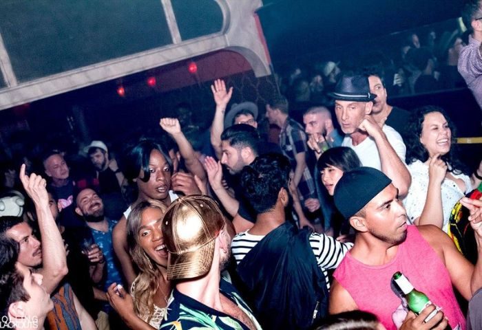 AKBAR party scene. Diverse crowd of gay men enjoying a night out dancing. Energetic atmosphere, nightlife. Gay travel advice.