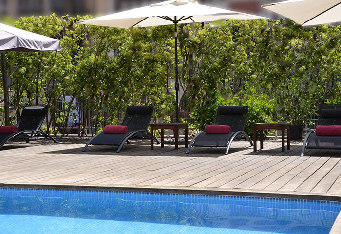 Acevi Villarroel Hotel, Barcelona's gay hotel: Outdoor pool with lounge chairs and umbrellas. A relaxing spot for gay travelers.