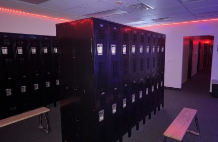 Adonis Health Club's locker room in Las Vegas. Black lockers line the walls, lit by red neon. Gay cruising spot.