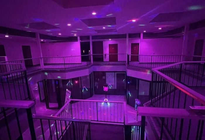 Interior of Adonis Health Club, a gay cruising spot in Las Vegas, featuring multi-level balconies and purple lighting. Nightlife travel.
