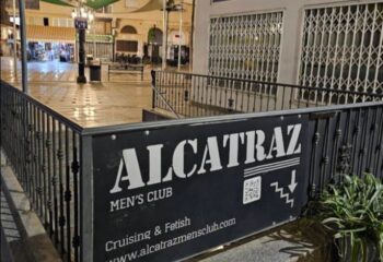 Entrance to Alcatraz Men's Club, a gay cruise club in Torremolinos. Sign with QR code and stairs down. Gay travel destination.