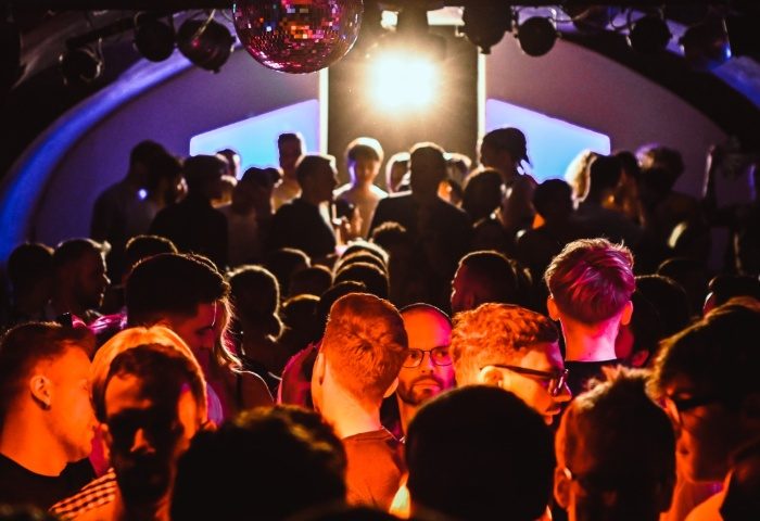 Crowd at AlterEGO Club Budapest, a popular gay venue. Disco ball, stage lights, and silhouettes of people create a vibrant nightlife scene.