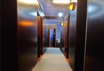 Amigo Sauna Copenhagen interior. Hallway view in this gay sauna. Dark wood cabins line the hall. Travel advice for gay men in Copenhagen.