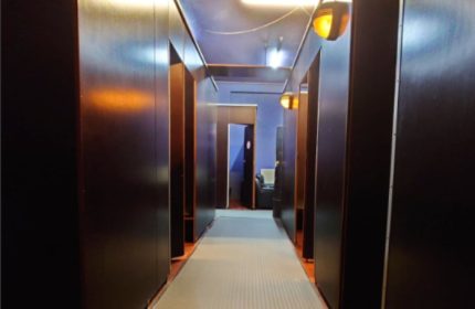 Amigo Sauna Copenhagen interior. Hallway view in this gay sauna. Dark wood cabins line the hall. Travel advice for gay men in Copenhagen.