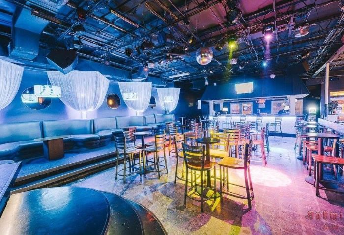 Aqua Bar, Key West gay nightlife. Dance floor, bar, & lounge seating. Disco ball, colorful lighting, and modern decor. Gay party venue.