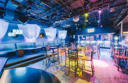 Aqua Bar, Key West gay nightlife. Dance floor, bar, & lounge seating. Disco ball, colorful lighting, and modern decor. Gay party venue.