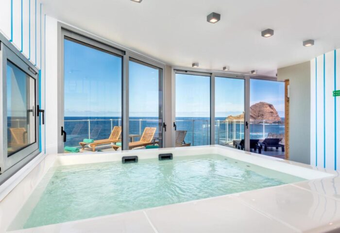 Aqua Natura Madeira gay-friendly hotel. Jacuzzi with ocean view. Deck chairs on the terrace. Relaxing gay travel destination.