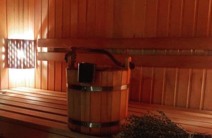Aquarius Sauna Istanbul: Interior view of a wooden sauna with bucket, ladle, and bench. Gay travel destination for relaxation.
