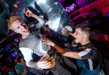 Gay Barcelona nightlife: Two men partying at Arena Xperience Gay Club. One is holding a beer and touching the other's chest. Fun times!