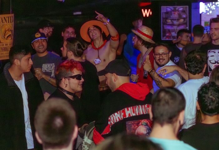 Gay nightlife in Barcelona: Arena Xperience gay club scene. Crowd of diverse men enjoying the party, some in costumes. Vibrant atmosphere.