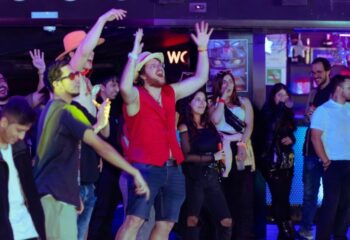 People dancing at Arena Xperience Gay Club in Barcelona. Nightlife scene with a diverse crowd enjoying music and drinks. Fun, vibrant atmosphere.