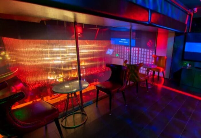 Shanghai gay travel: Stylish interior of a bar in Asia, featuring colorful lights, tables, and chairs. Nightlife scene, perfect for gay men's travel adventures.