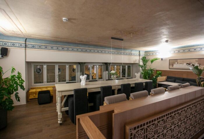 Athens 1890 Hotel & Spa dining area. Gay-friendly hotel interior with long table, chairs, and plants. Adults-only accommodation in Athens.