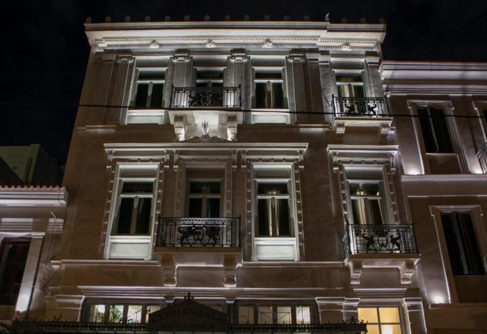 Athens 1890 Hotel & Spa, adults only, gay-friendly. Exterior view of the hotel at night. Balconies on the upper floors. Elegant architecture.