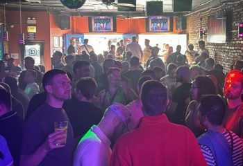Crowded gay bar, Atmosphere, in Andersonville, Chicago. Live music venue with diverse crowd enjoying drinks and socializing. Nightlife scene.