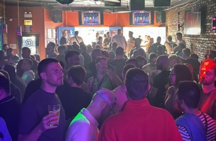 Crowded gay bar, Atmosphere, in Andersonville, Chicago. Live music venue with diverse crowd enjoying drinks and socializing. Nightlife scene.