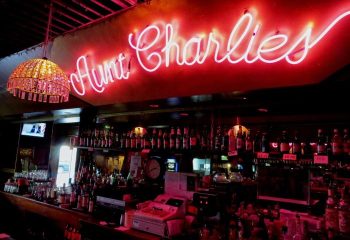 Aunt Charlie's Lounge bar in San Francisco. Neon sign above a fully stocked bar. Popular gay bar and travel destination.