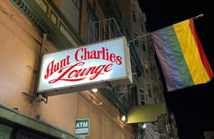 Aunt Charlie's Lounge in San Francisco. Gay bar with rainbow flag. Night view of the bar's sign. Gay travel advice.