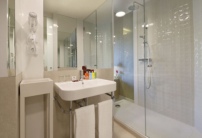 Bathroom at Axel Hotel Barcelona, a gay adults-only urban spa. Modern design with walk-in shower, sink, and toiletries. Most booked gay hotel.