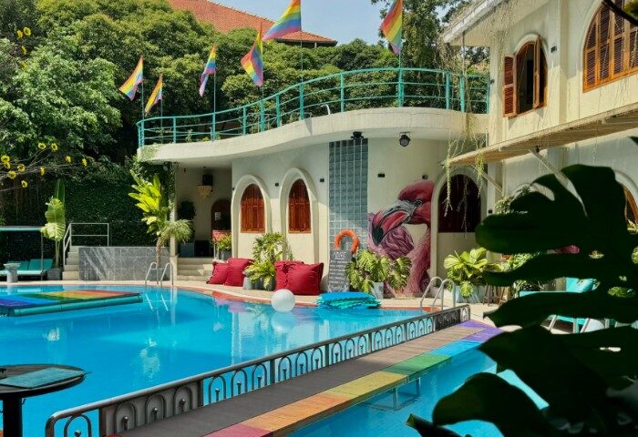 Azure Pool Bar in Ho Chi Minh City: Gay travel destination with rainbow flags, flamingo mural, vibrant pool, and lush greenery.