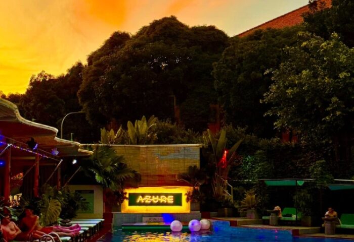 Azure Pool Bar in Ho Chi Minh City. Gay travel destination with pool, bar, lush greenery, and sunset. Popular spot for gay men.