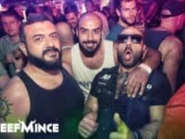 BEEFMINCE Gay Party Organiser: Three bearded men pose at a gay party. One wears sunglasses and has his mouth open in excitement. Nightlife scene.