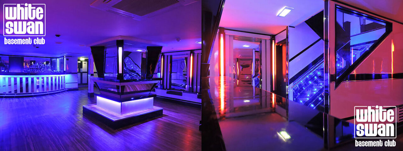 Interior of BJ's White Swan gay club. Bar, stage, and hallway with neon lighting. Gay travel advice. BJs-White-Swan-Gay-Club.jpg