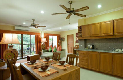 Baan Souy Resort interior. Dining table, kitchen, and living area in this gay adults-only hotel in Pattaya. Service apartment living.