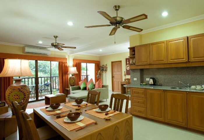 Baan Souy Resort interior. Dining table, kitchen, and living area in this gay adults-only hotel in Pattaya. Service apartment living.