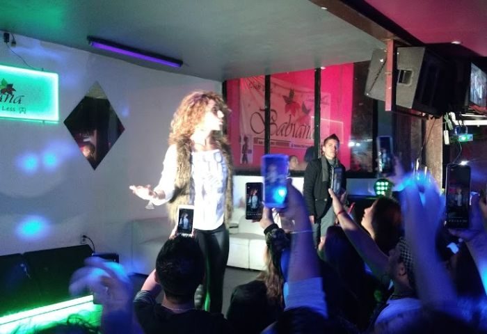 Babilonia Baby Club gay bar in Mexico: Drag queen performing on stage as people record with phones. Gay nightlife travel advice.