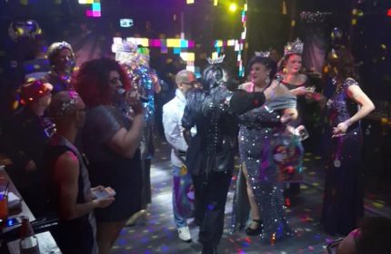 Badlands Las Vegas gay bar scene. Drag queens with crowns, one singing, at a pageant show. Gay nightlife in Las Vegas.