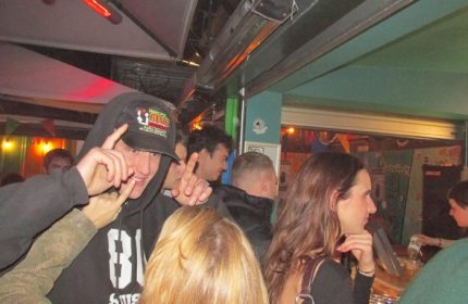 Baggen Copenhagen: Gay men at a bar in Copenhagen, Denmark. The man in the foreground is wearing a black hoodie and a baseball cap.