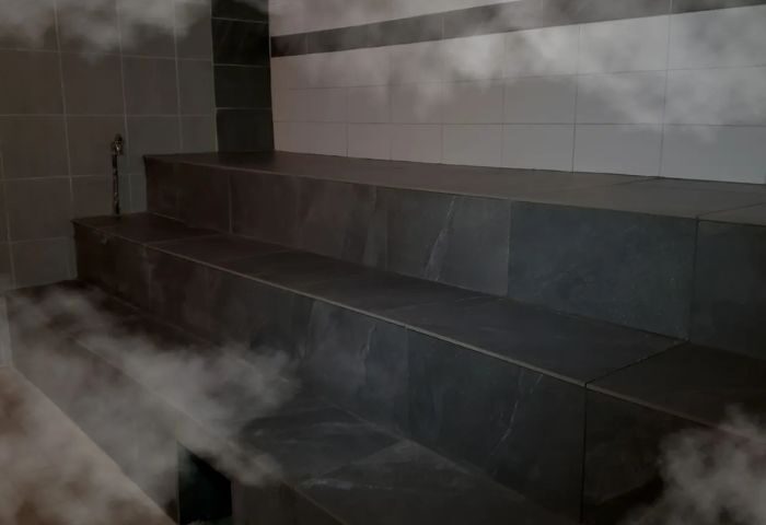 Bain Colonial bath, Montreal gay spa. Tiled steps in a steam room, part of the gay sauna experience. Relaxing atmosphere for gay travel.