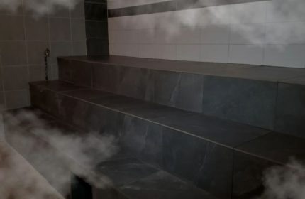 Bain Colonial bath, Montreal gay spa. Tiled steps in a steam room, part of the gay sauna experience. Relaxing atmosphere for gay travel.
