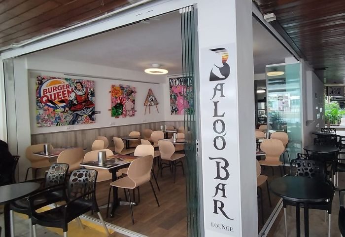 Baloo Bar Lounge, a gay bar in Torremolinos. Interior view with tables, chairs, and colorful pop art. A popular gay travel destination.