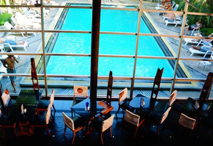 Babylon Bangkok Hotel's pool view from the restaurant. Gay hotel near Silom, Thailand. Men relax by the pool at this top gay sauna spot.