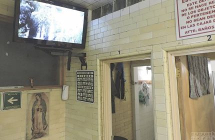 Finisterre Gay Sauna in Mexico: Interior view with TV, religious iconography, and safety instructions. A unique travel experience for gay men.