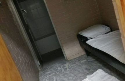 Banos Finisterre gay sauna in Mexico: Interior view of a room with a bed and a shower. Gay travel advice in Mexico.