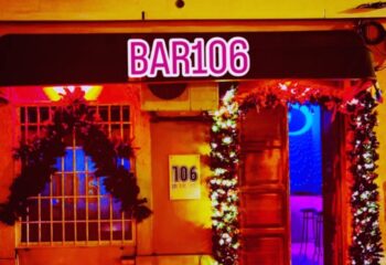 Bar 106 in Lisbon, Portugal. Gay bar exterior at night, decorated with festive garlands. Travel destination for gay men.